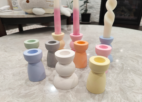 Colorful ceramic candle holders on a light surface